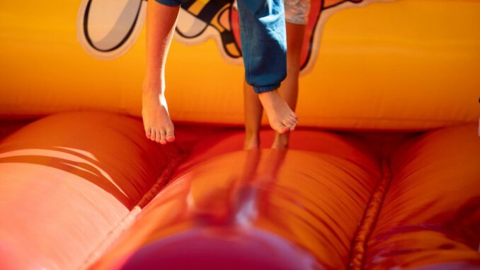 A young boy jumping on a bouncy castle